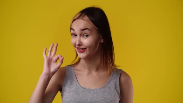 Slow Motion Video One Girl Showing Thumbs Smiling Yellow Background — Vídeos de Stock