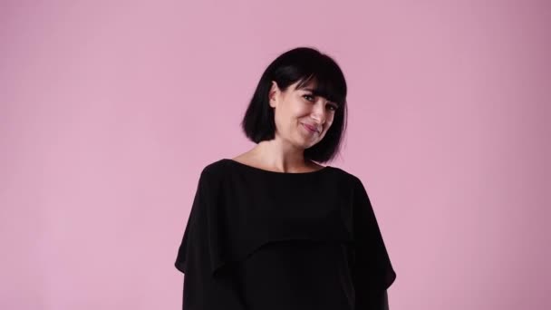 ピンクの背景に狡猾な顔の表情を持つ女性の4Kビデオ アイデアを持つ女性の概念 — ストック動画