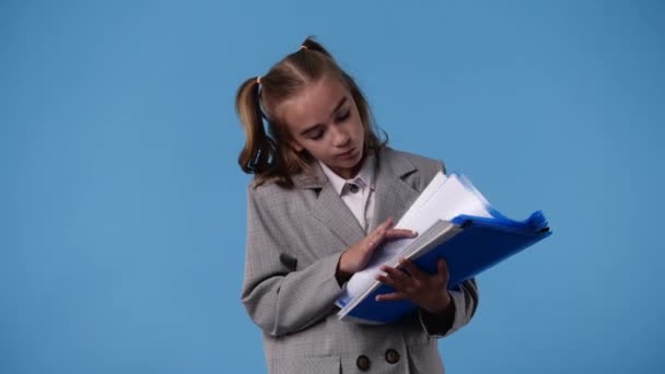 Vídeo Uma Menina Tomando Notas Sobre Fundo Azul Conceito Emoções — Vídeo de Stock