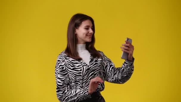 Видео Женщины Использующей Свой Телефон Желтом Фоне Концепция Эмоций — стоковое видео