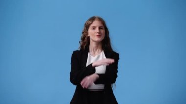 Mavi arka planda çapraz elleri olan bir kızın 4K videosu. Olumsuz duygu kavramı.