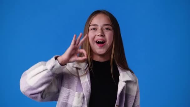 Video Cute Girl Showing Sign Blue Background Concept Emotions — Stockvideo