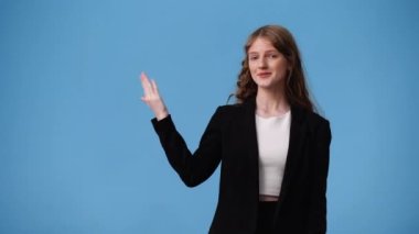 Sol tarafı işaret eden bir kızın mavi arkaplanı gösteren 4K videosu. Duyguların kavramı.