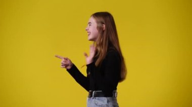 Sarı arka planda bir kızın sağa sola baktığı 4k 'lık bir video. Duyguların kavramı.