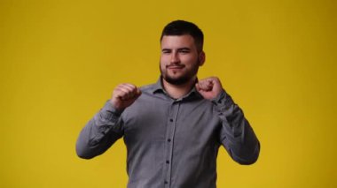4k video of one man posing for a video over yellow background. Concept of emotions.