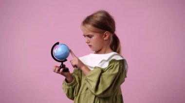 4k video 'da bir kız pibk arka planında küçük bir küreye bakıyor. Duyguların kavramı.