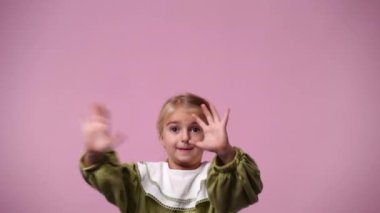 4k video of one girl posing for a video over pink background. Concept of emotions.