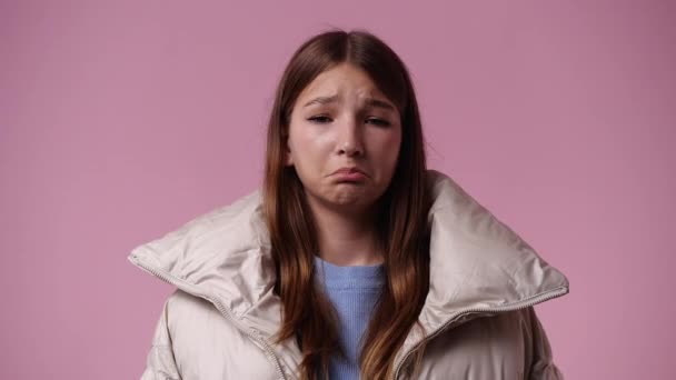 ピンクを背景に否定的な表情をした1人の少女の4Kビデオ 感情の概念 — ストック動画