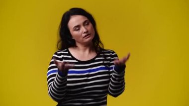 4k video of one girl posing for a video on yellow background. Concept of emotions.