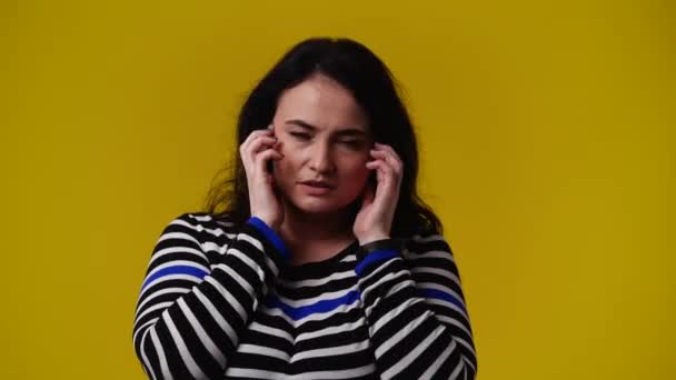 黄色の背景の上に手を頭に置くことによって何かを計画する1人の女性の4Kビデオ 感情の概念 — ストック動画