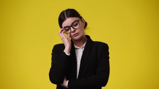 Vídeo Uma Garota Que Tira Óculos Pensa Sobre Fundo Amarelo — Vídeo de Stock