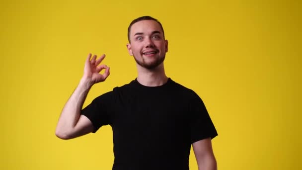 一个男人在黄色背景上显示一个Ok标志的4K视频 情绪的概念 — 图库视频影像