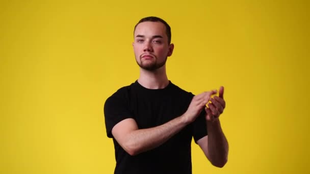 一个男人的4K视频拍拍他的手在黄色背景上 情绪的概念 — 图库视频影像