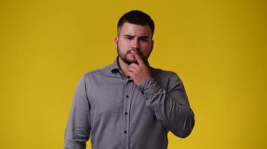 4k video of one man posing for a video over yellow background. Concept of emotions.