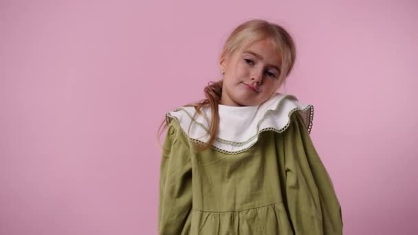 4K视频 女孩在粉色背景下 用狡猾的面部表情触摸她的脸 情绪的概念 — 图库视频影像