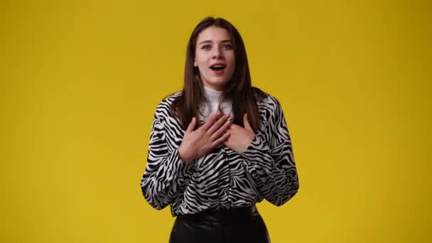 一个女孩的4K视频是如此兴奋的东西在黄色的背景 情绪的概念 — 图库视频影像