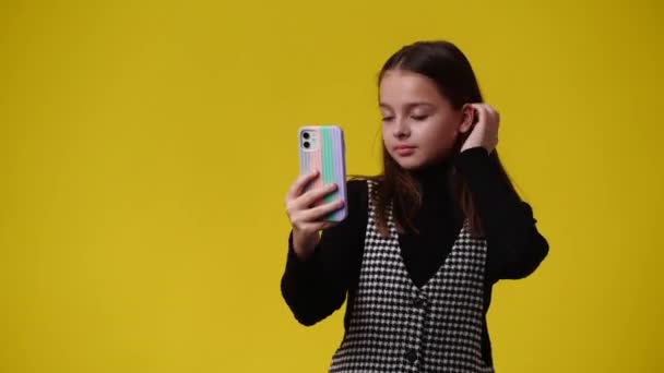在黄色背景下 女人用手机自拍的4K视频 情感的概念 — 图库视频影像