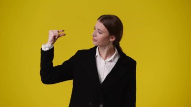 Sarı arka planda kurnaz yüz ifadesi olan bir kızın 4K videosu. Fikirleri olan kız kavramı.