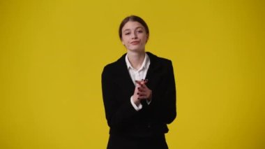 Sarı arka planda poz veren bir kızın 4K videosu. Fikirleri olan kız kavramı.