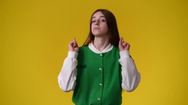 4k video of one girl showing thumbs up over yellow background. Concept of emotions.