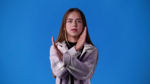 Vídeo Uma Menina Com Mãos Cruzadas Fundo Azul Conceito Emoção — Vídeo de Stock