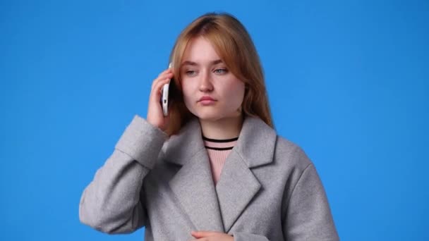 Vídeo Cute Girl Using Phone Blue Background Conceito Emoções — Vídeo de Stock