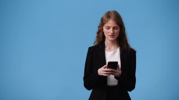 Wideo Cute Girl Pomocą Telefonu Niebieskim Tle Pojęcie Emocji — Wideo stockowe