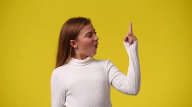 4k video of cute girl smiling over yellow background. Concept of emotions.