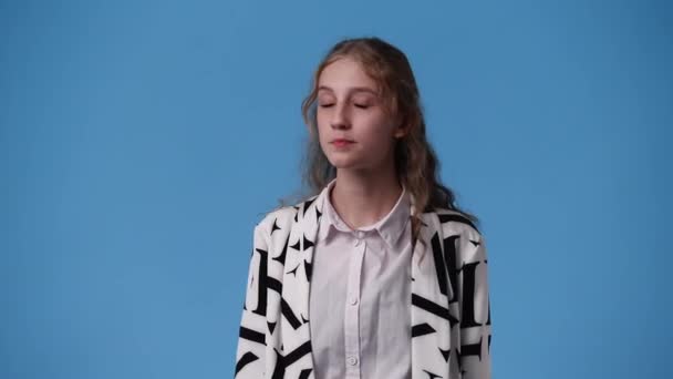 4K视频 一个女孩在蓝色背景下微笑 情绪的概念 — 图库视频影像