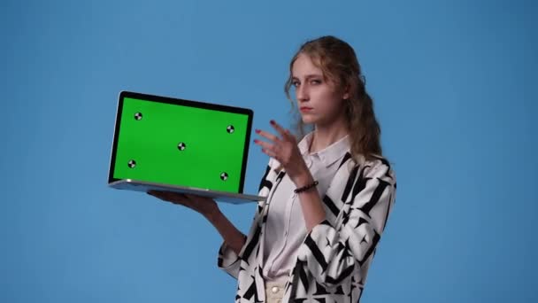 クロマキーノートパソコンを使った1人の女の子の4Kビデオと青の背景の上に何かを考える 感情の概念 — ストック動画