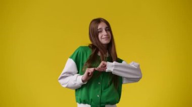 Sarı arka planda kurnaz yüz ifadesi olan bir kızın 4K videosu. Fikirleri olan kız kavramı.