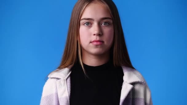 青を背景に否定的な表情をした1人の少女の4K動画 感情の概念 — ストック動画