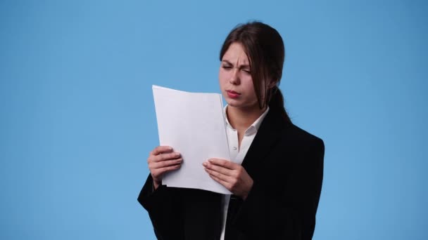 青い背景の紙で何かを考えている1人の少女の4Kビデオ 感情の概念 — ストック動画