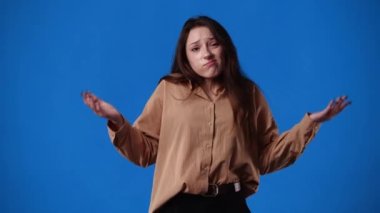Bir kızın mavi arka planda bir şeyler düşündüğü 4K video. Duyguların kavramı.