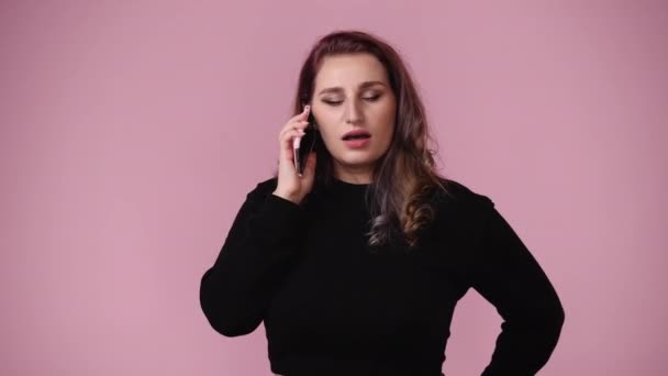 ピンクを背景に否定的な表情をした1人の少女の4Kビデオ 感情の概念 — ストック動画