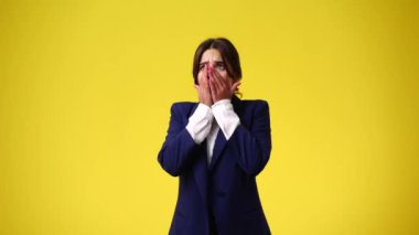 4k video of one girl with negative facial expression over yellow background. Concept of emotions.