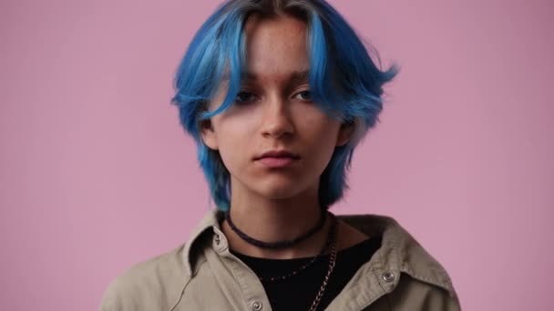 青い髪をした1人の女の子の4K動画はピンクの背景の上に何かに興奮しています 感情の概念 — ストック動画