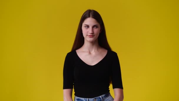 黄色の背景に無音記号を示す1人の少女の4K動画 感情の概念 — ストック動画