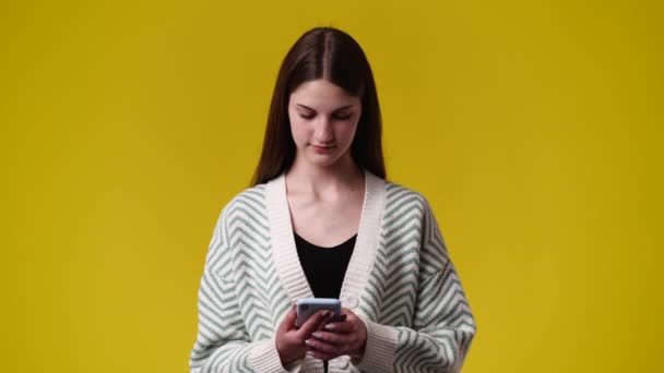 Vídeo Uma Menina Usando Seu Telefone Sobre Fundo Amarelo Conceito — Vídeo de Stock