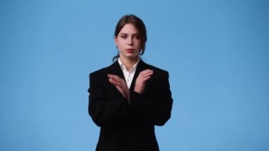 Mavi arka planda gülümseyen güzel bir kızın 4K videosu. Duyguların kavramı.