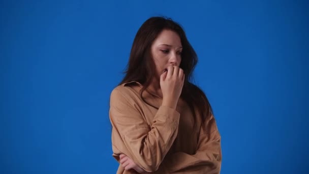 Video Flicka Som Mycket Orolig För Något Över Blå Bakgrund — Stockvideo