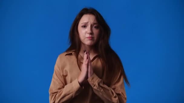 青い背景で嘆願する1人の少女の4Kスローモーションビデオ 感情の概念 — ストック動画