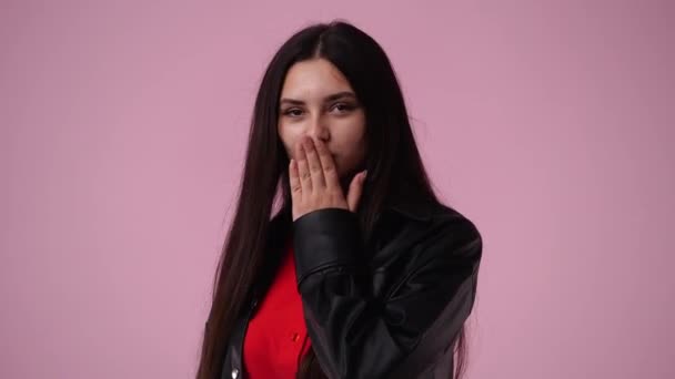 1人の女の子の4K動画が笑ってピンクの背景に空気のキスを送る 感情の概念 — ストック動画