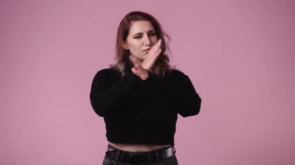 ピンクを背景に否定的な表情で誰かを止める1人の女の4K動画 感情の概念 — ストック動画