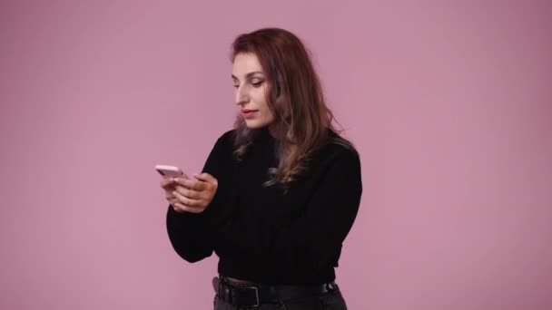 Video Kvinna Som Pekar Telefonen Över Rosa Bakgrund Begreppet Känslor — Stockvideo