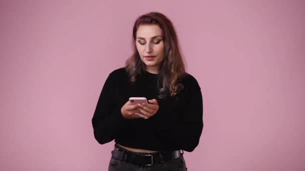 Videó Egy Nőről Aki Jobbra Mutat Kezében Tartja Telefont Rózsaszín — Stock videók