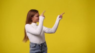 Sarı arka planda sağ tarafı gösteren bir genç kızın 4K videosu. Duyguların kavramı.