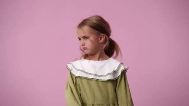 ピンクの背景に否定的に反応する1人の子供の4Kビデオ 感情の概念 — ストック動画