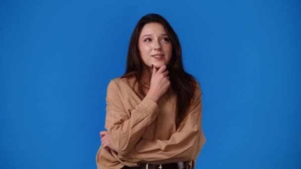 Vídeo Uma Garota Que Sonha Com Algo Sobre Fundo Azul — Vídeo de Stock