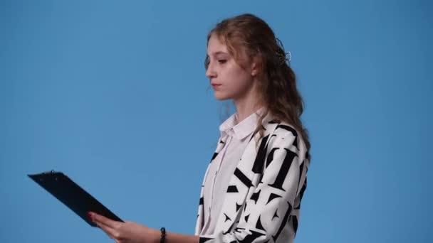 Βίντεο Ένα Κορίτσι Σκέφτεται Κάτι Χαρτιά Μπλε Φόντο Έννοια Των — Αρχείο Βίντεο